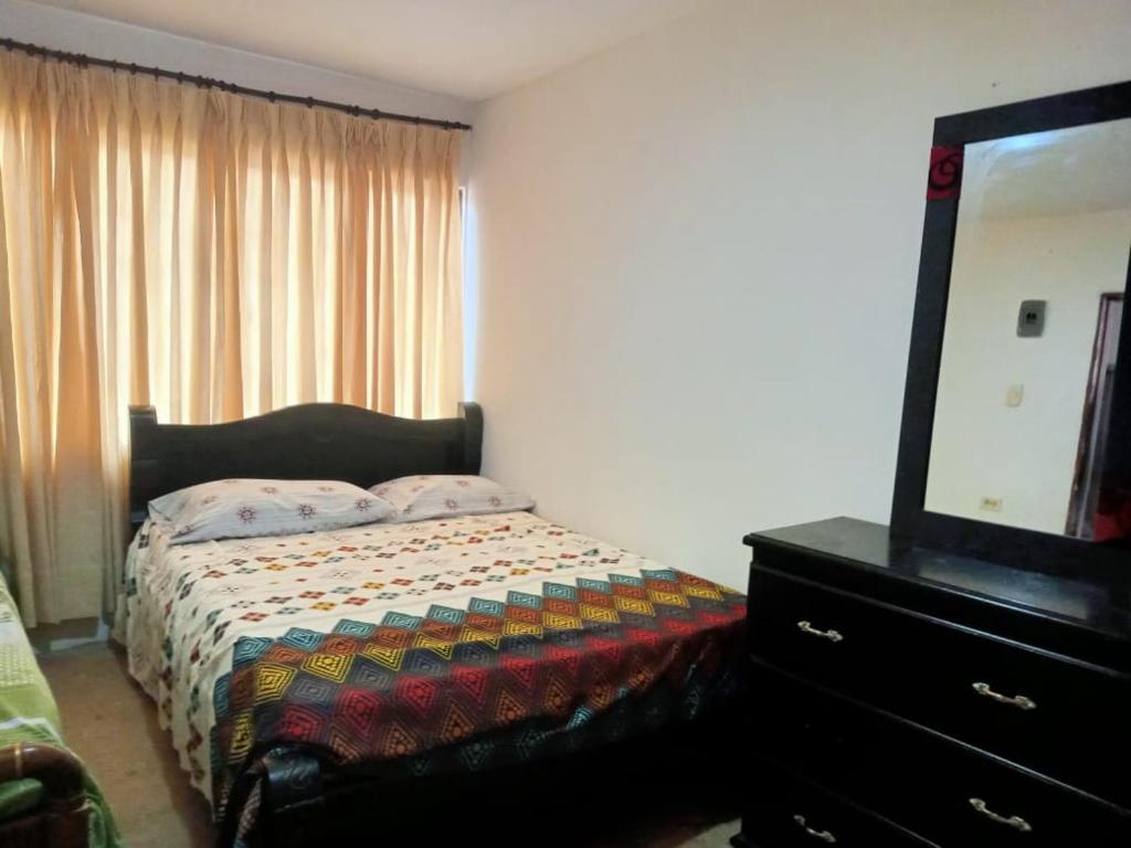 - une chambre avec un lit et une commode avec une télévision dans l'établissement Hotel Caribe, 