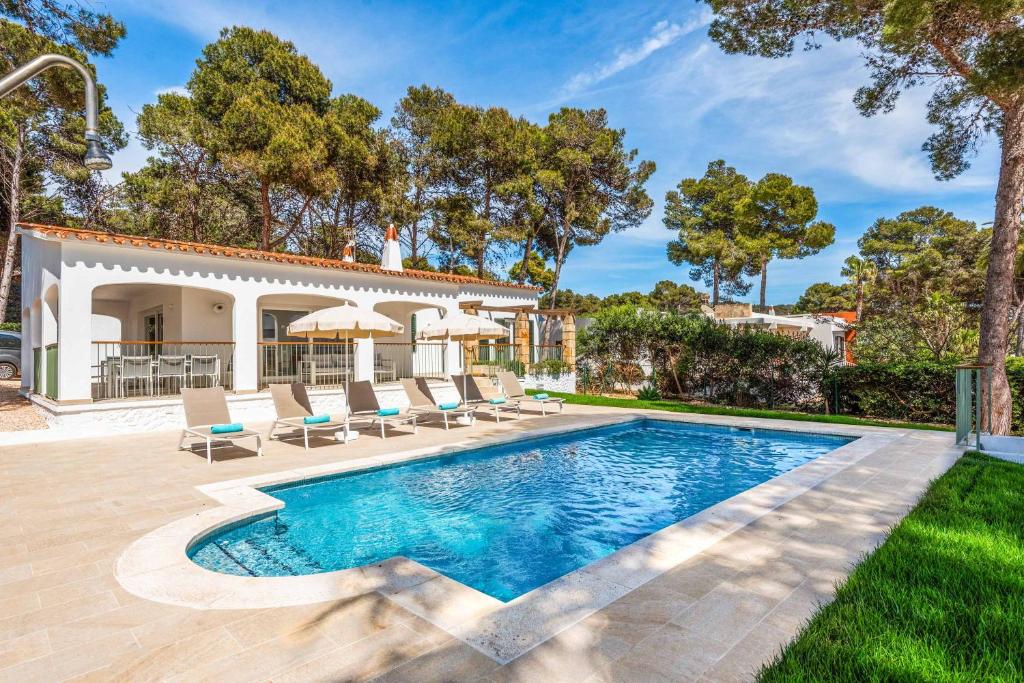 a pool with lounge chairs and a house at Villa Gabriela in Santo Tomás