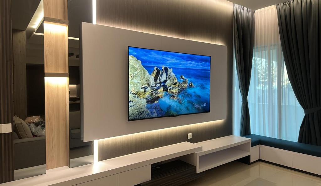 ルムットにあるGrand’e La Villa Homestayの壁に薄型テレビが取り付けられたリビングルーム