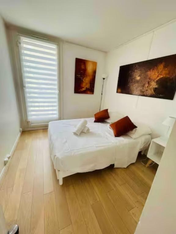a bedroom with a white bed and a wooden floor at Chambre double dans appartement, fibre, RER B in Antony