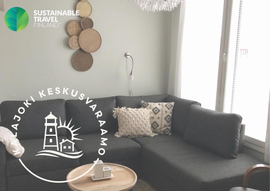 a living room with a gray couch with a lighthouse stencil at Seastar 101 in Kalajoki