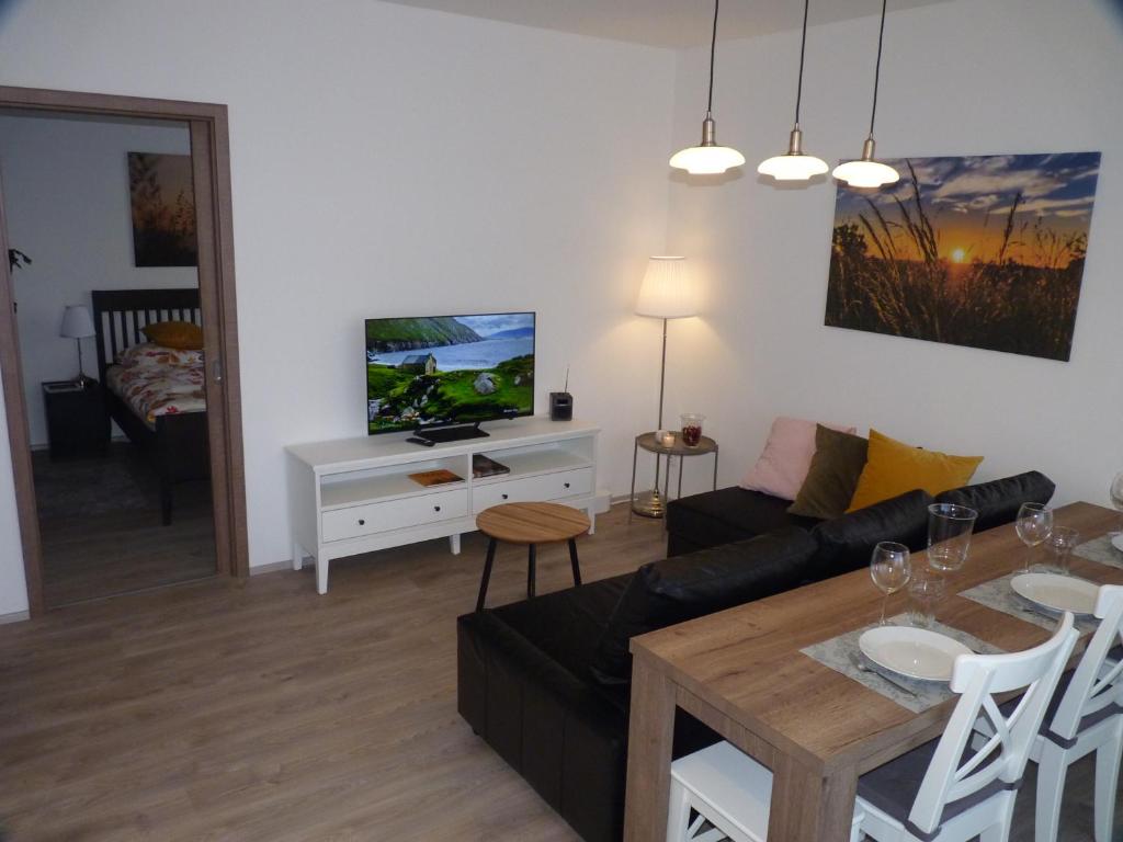 uma sala de estar com um sofá e uma mesa em Apartmán Trilobit em Beroun