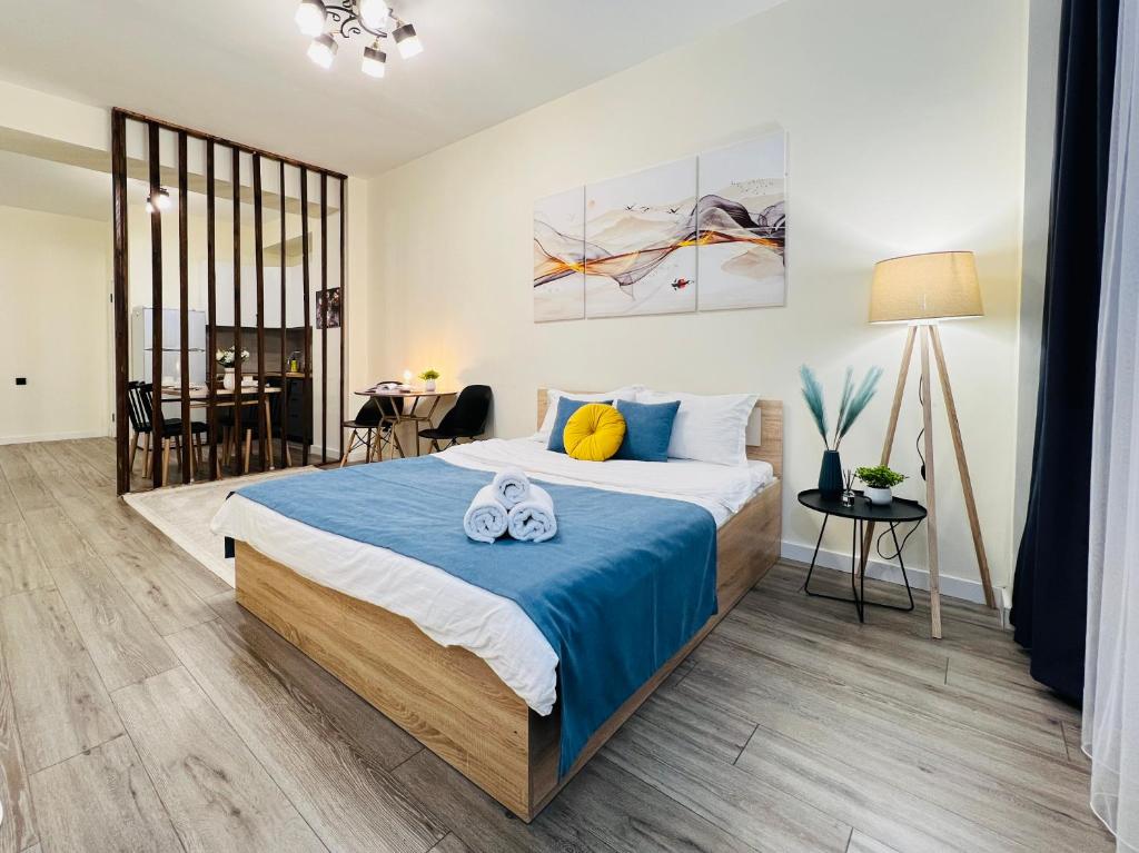 アルマトイにある417I3 Sky Blue Apartments Sholpan cityのベッドとタオル2枚のある寝室