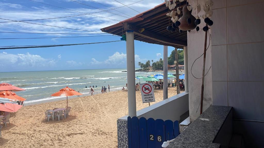 a beach with umbrellas and people on the beach at Casa em Baia Formosa-RN in Baía Formosa