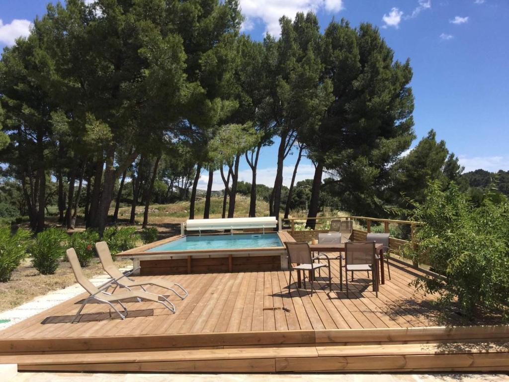 eine Terrasse mit einem Tisch und Stühlen neben einem Pool in der Unterkunft typical provencal farm in an exceptional natural site, the alpilles park - 8 people. in Les Fléchons