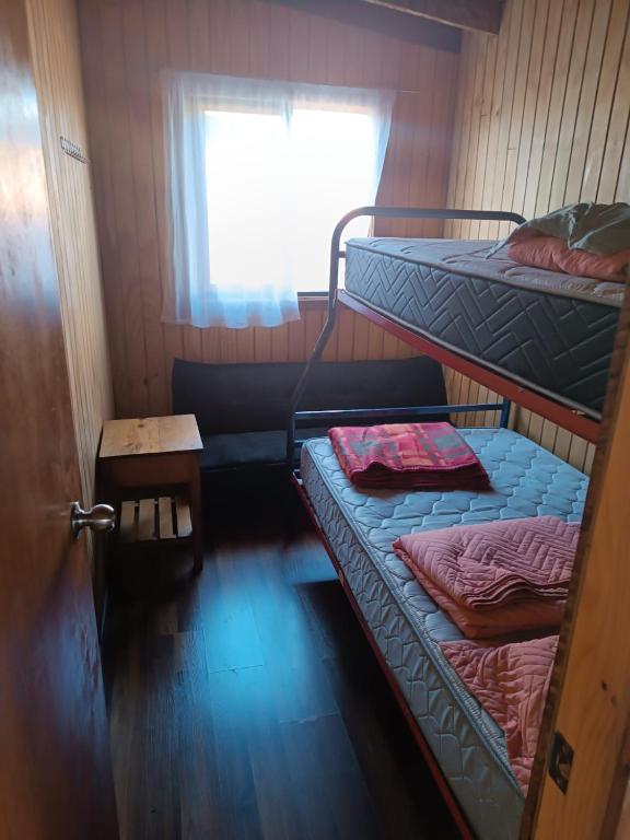 Cette chambre comprend 2 lits superposés et une fenêtre. dans l'établissement Don Agustín, à Lago Ranco