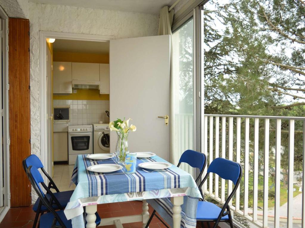una mesa con un mantel azul y blanco en el balcón en Appartement Argelès-sur-Mer, 2 pièces, 5 personnes - FR-1-225-426 en Argelès-sur-Mer