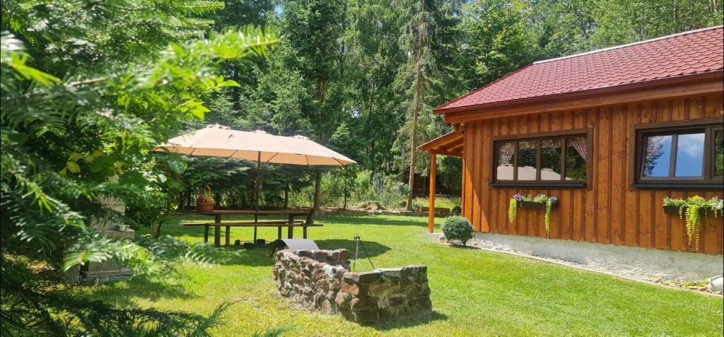 una cabina di legno con tavolo e ombrellone di Chaloupka U Matušků a Varnsdorf