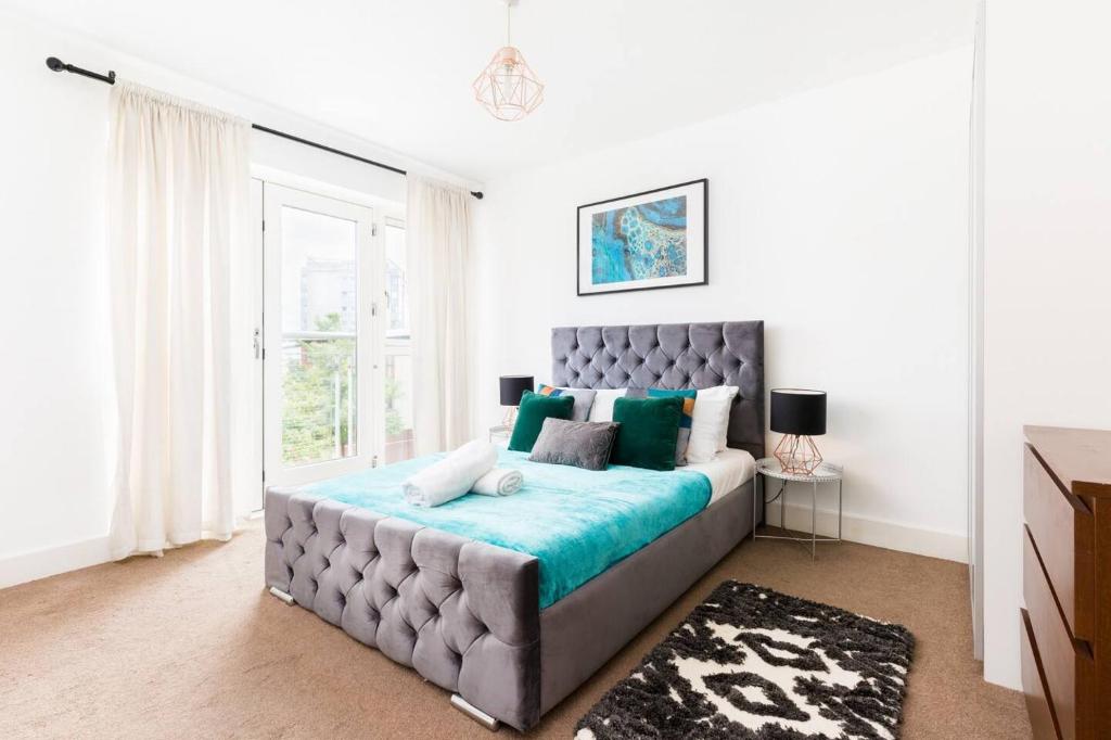 a bedroom with a large bed with a blue blanket at Spacious City Centre Apartment - Balcony - Smart TV - WIFI- 448A in Birmingham
