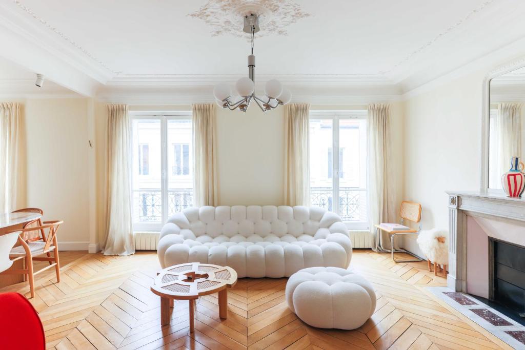 sala de estar con sofá blanco y chimenea en Beautiful 95m2 flat in the heart of Neuilly Sur Seine, en Neuilly-sur-Seine