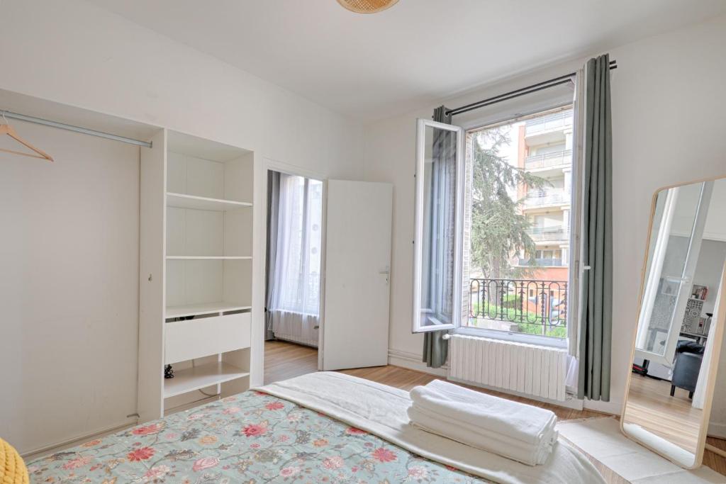 a white room with a bed and a large window at Flowers Power - Appt pour 2 in Vitry-sur-Seine