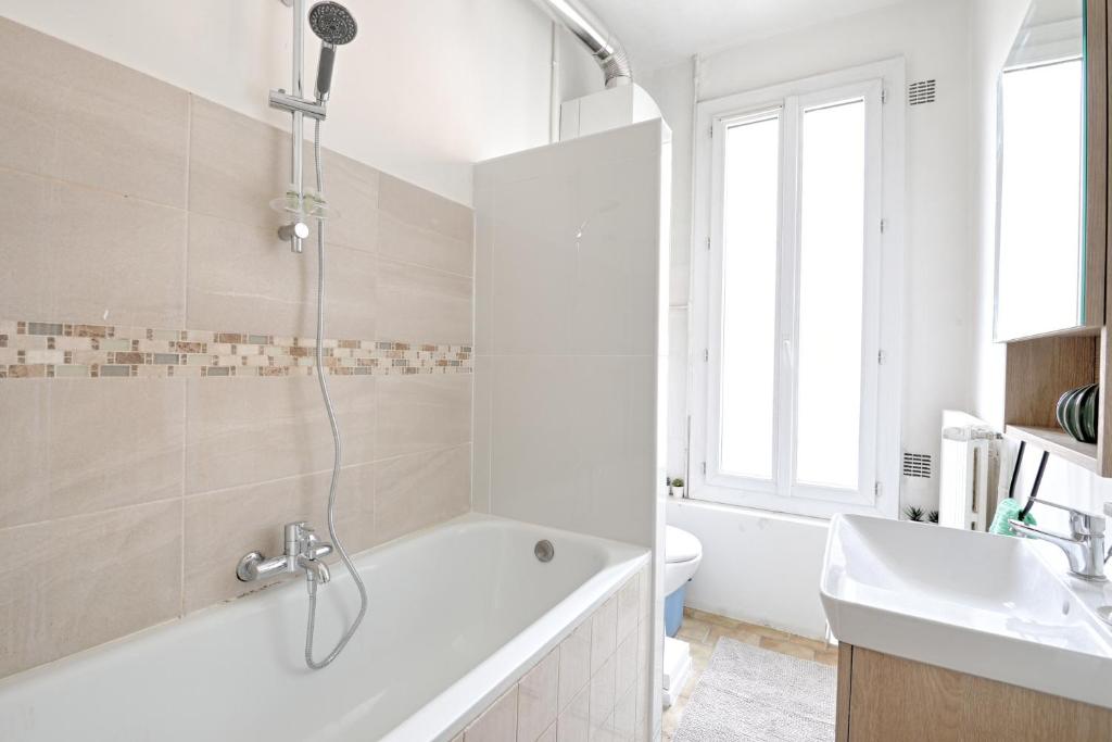 a white bathroom with a tub and a sink at Flowers Power - Appt pour 2 in Vitry-sur-Seine