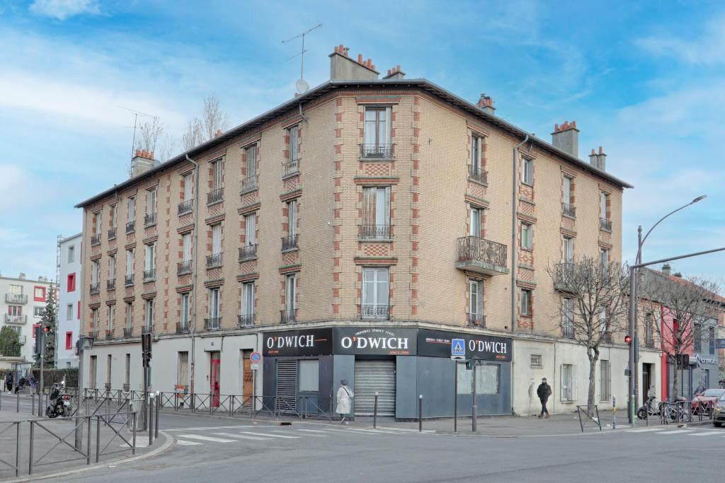 a large brick building on the corner of a street at Flowers Power - Appt pour 2 in Vitry-sur-Seine