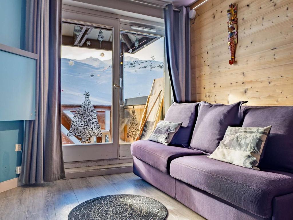 - un salon avec un canapé violet en face d'une fenêtre dans l'établissement Val Thorens : Appartement 4 pers rénové avec balcon, local à ski, au pied des pistes - FR-1-637-70, à Val Thorens