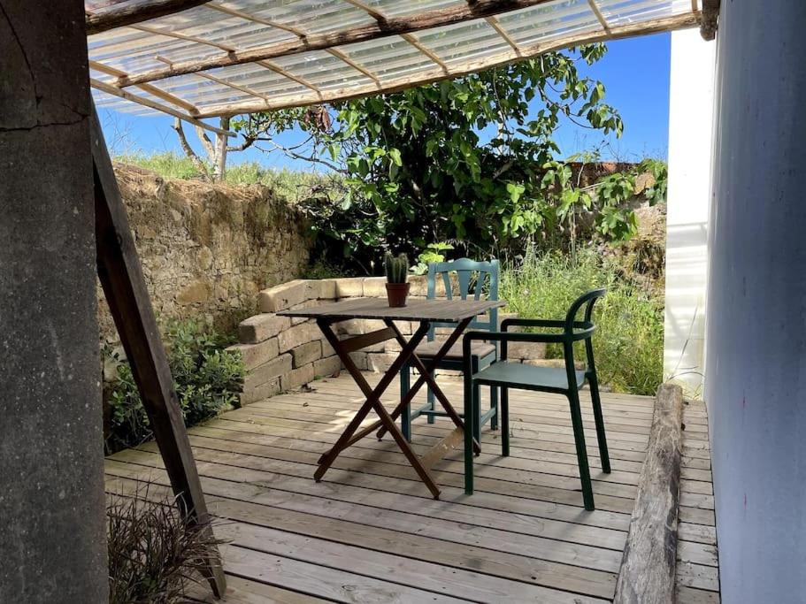 a table and two chairs on a wooden deck at Casa Bonabal- 15 min from Ericeira 