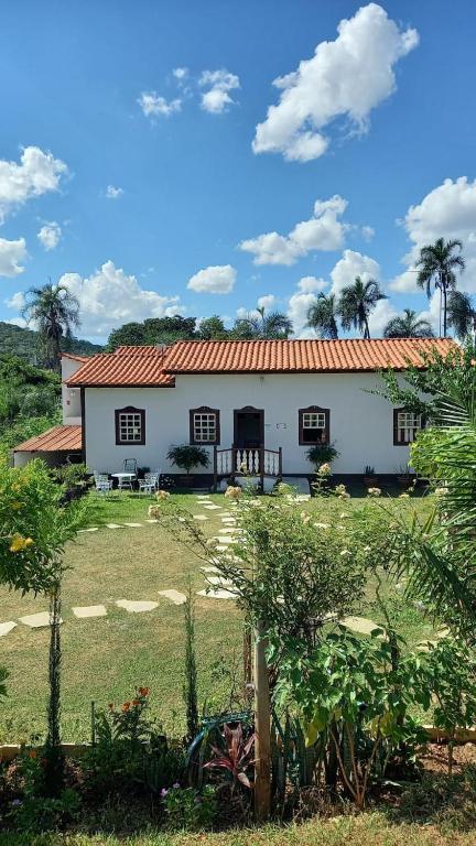 duży biały dom z czerwonym dachem w obiekcie Casa Nobre w mieście Pirenópolis