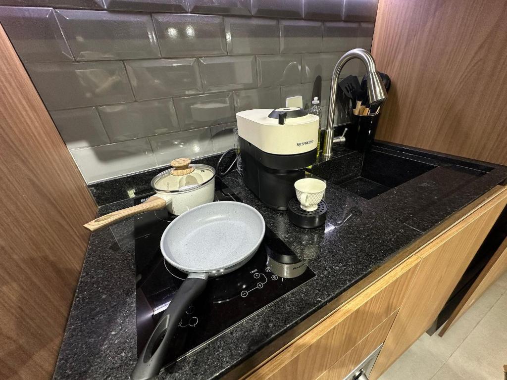 a kitchen counter with a sink with a pot on it at Ap Luxo Jardins Cd 707 in São Paulo