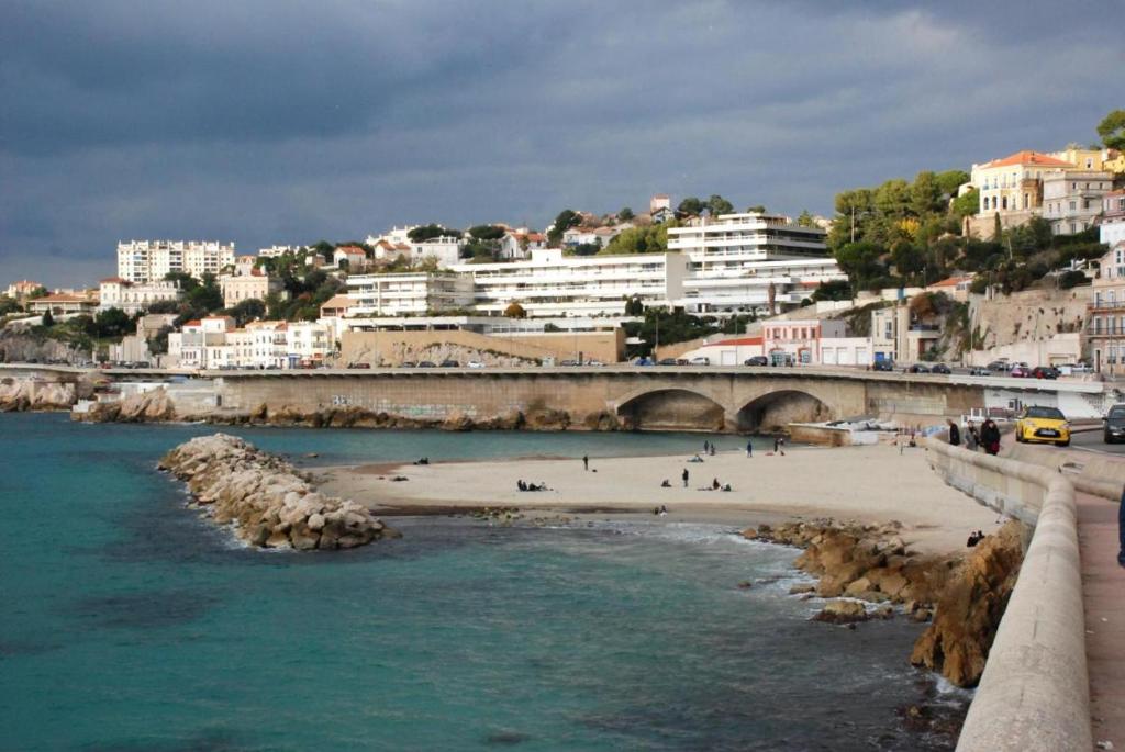 a view of a beach with a bridge and buildings at Le Passe-Port pour Marseille in Marseille