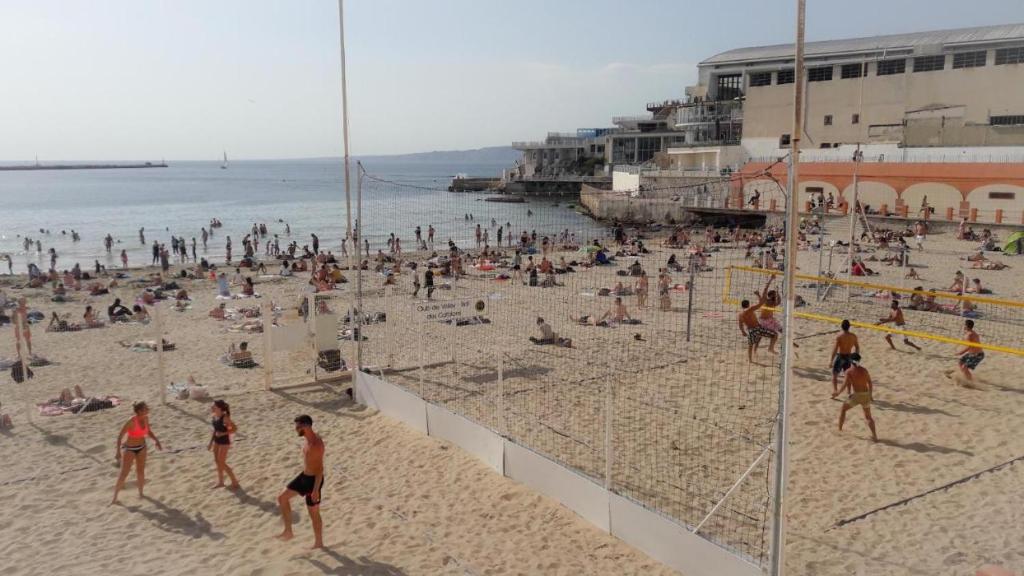 a group of people playing volleyball on a beach at Le Passe-Port pour Marseille in Marseille