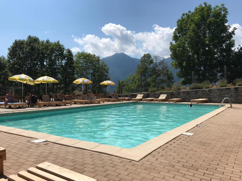 a swimming pool with chairs and umbrellas in a resort at Campeggio Cianabie in Sampeyre