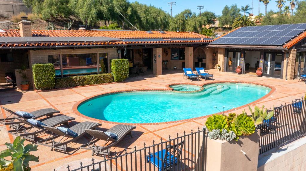 H1 California Adobe Estate at Moonlight Ranch, Views, Private, Heated pool, Jacuzzi, Petting zoo! في فيستا: اطلالة علوية على مسبح مع كراسي ومنزل