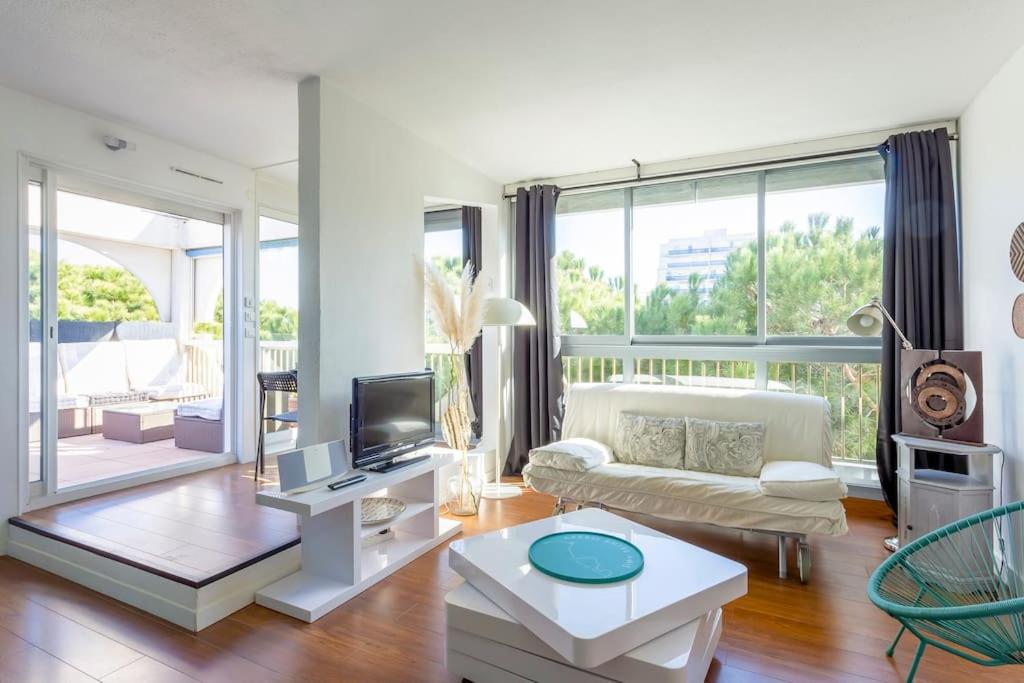 un salon avec un canapé et une télévision dans l'établissement Chez Muriel - Fabuleux appartement en centre ville avec parking, à La Grande Motte
