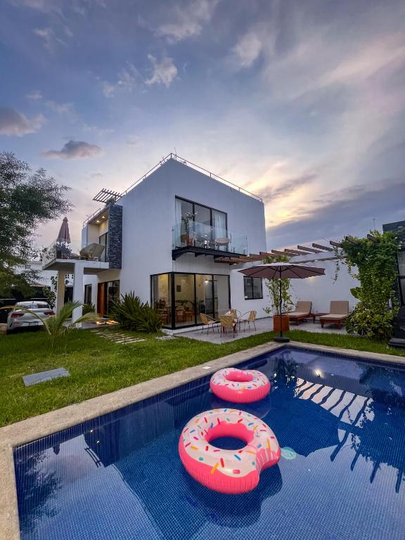 a villa with a swimming pool and a house at Casa Tres Iguanas, La Punta in Puerto Escondido