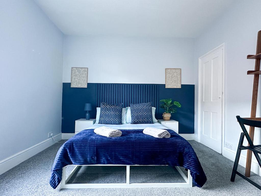 a blue bedroom with a bed with blue walls at Stylish 3-bedroom home in Canterbury City-Centre - Superb Location! in Canterbury