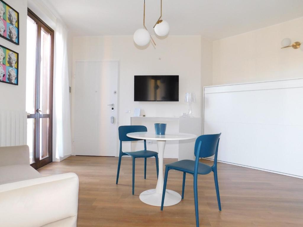 a dining room with a white table and blue chairs at Casa Jotti in Cardano al Campo