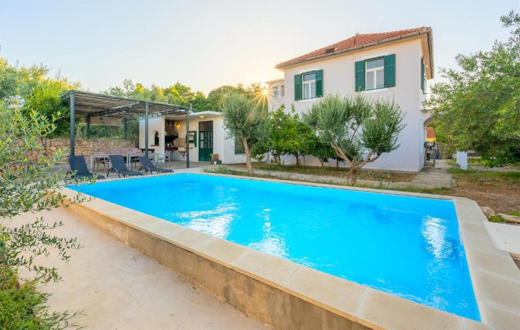 a swimming pool in the backyard of a house at Awesome Home In Kolocep With Heated Swimming Pool in Koločep