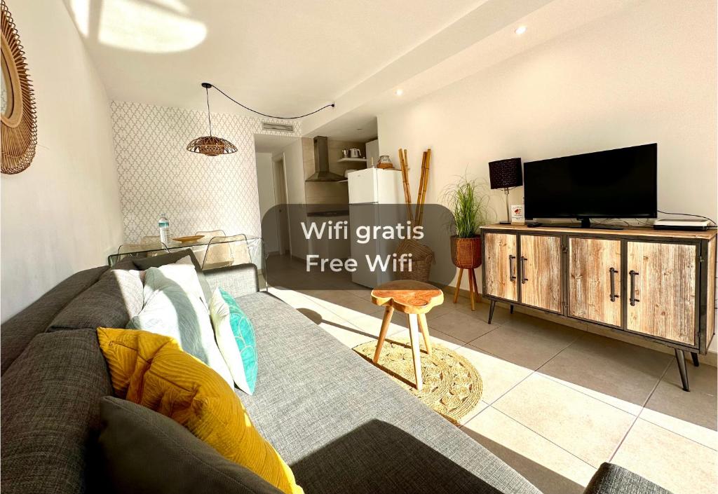 een woonkamer met een bank en een tv bij Maracuyá con piscina, terraza, smart tv, cocina completa y WIFI in Corralejo