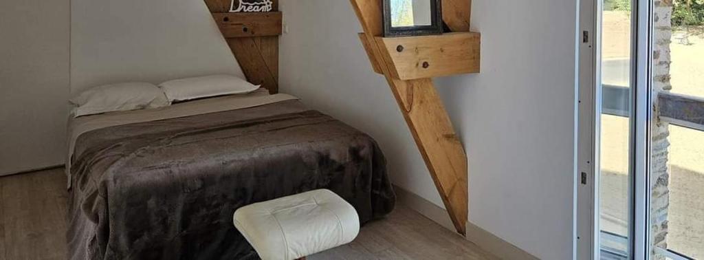 ein kleines Schlafzimmer mit einem kleinen Bett und Holzboden in der Unterkunft L'Ecrin - Rubis in Châteaubriant