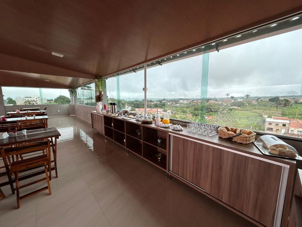 a kitchen with a long counter with a large window at Hotel Carvalho in Ibiapina