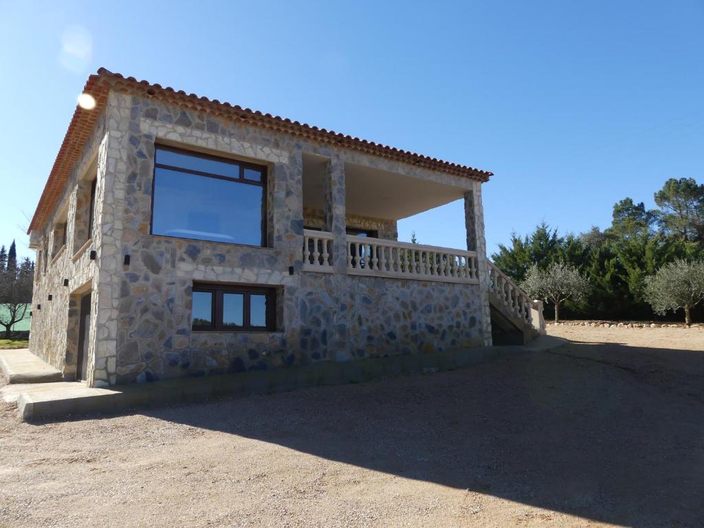 ein Steinhaus mit einem Fenster auf der Seite in der Unterkunft El Rodenal in Valera de Abajo