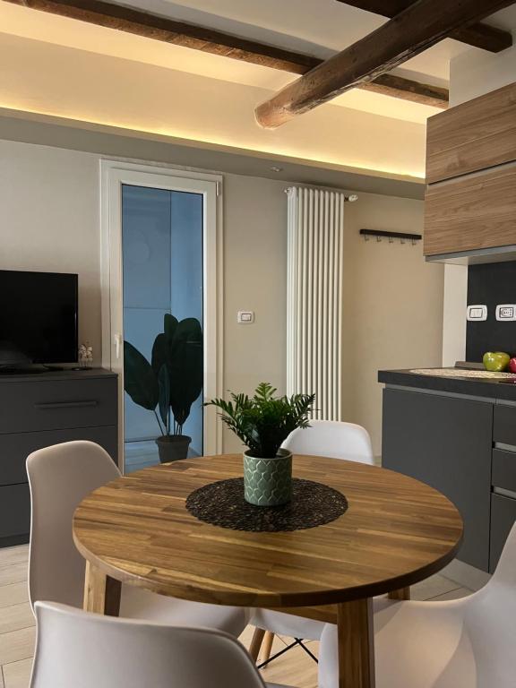 a kitchen and dining room with a wooden table and chairs at BolognaBySide-DE FALEGNAMI in Bologna