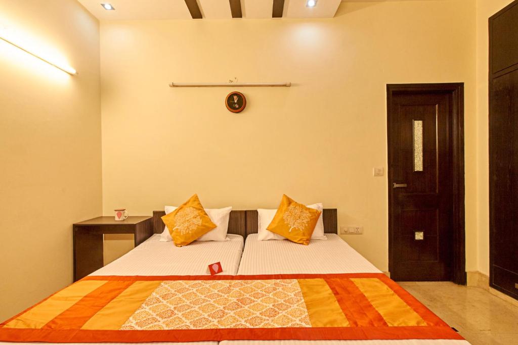 a bedroom with two beds and a clock on the wall at OYO 3594 Kamla Nagar in New Delhi