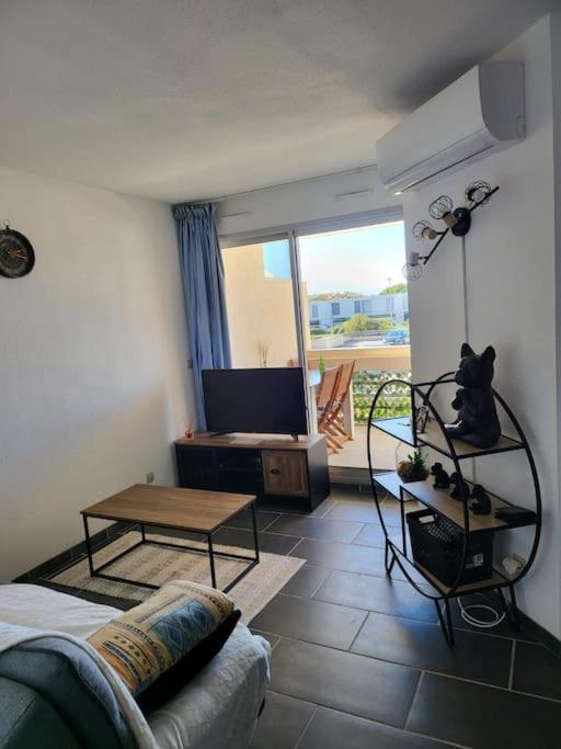 un salon avec un canapé et une table dans l'établissement location les pieds dans l'eau, à Canet