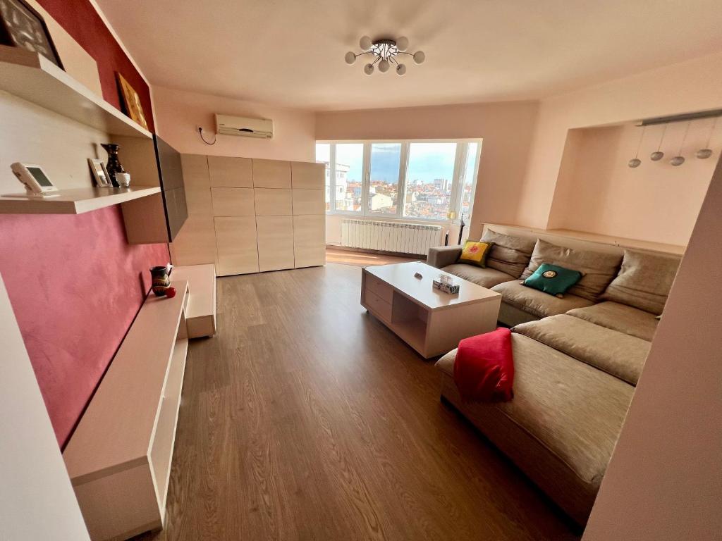 ein Wohnzimmer mit einem Sofa und einem Tisch in der Unterkunft Amy's Bright Apartment in Constanţa