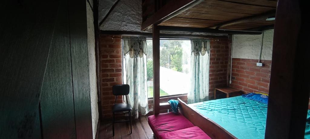 ein Schlafzimmer mit einem Bett und einem Fenster in einem Zimmer in der Unterkunft Casa de Salomon in Quito