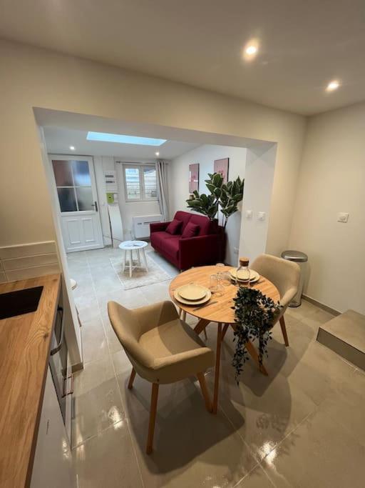 un salon avec une table et un canapé rouge dans l'établissement La Maisonnette, à Rouen