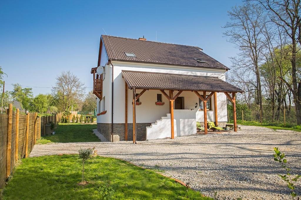 Nitrianska Blatnica的住宿－Melior Wellness，一间白色的小房子,有棕色的屋顶