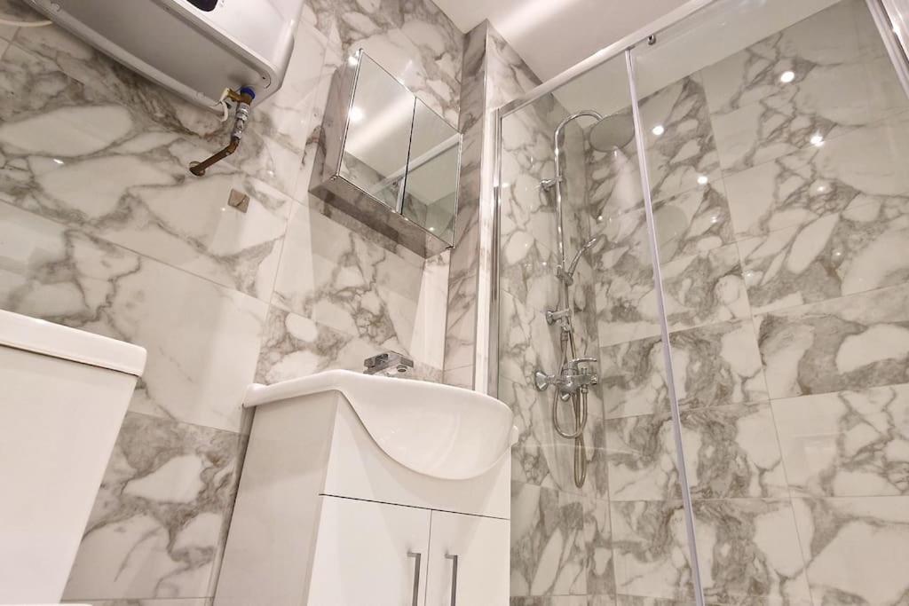 a bathroom with a shower and a toilet and a sink at Warm 1-bedroom London apartment in London