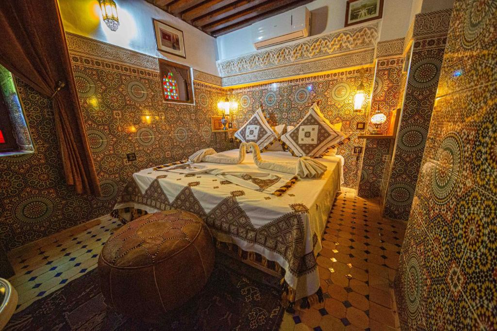 a bedroom with a large bed in a room with tiles at Riad Le Petit Patrimoine De Fés in Fès