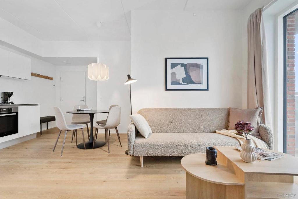 a living room with a couch and a table at Seaside apartment with magical balcony view in Aarhus