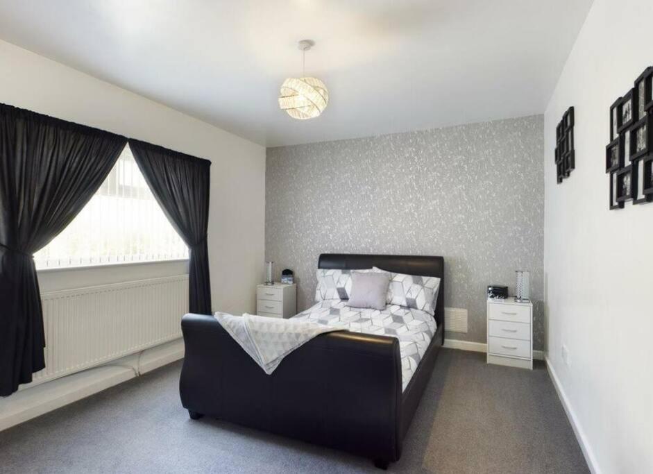 een slaapkamer met een bed en een raam bij Work & Relax - 2 bedroom house with off-road parking in Swansea