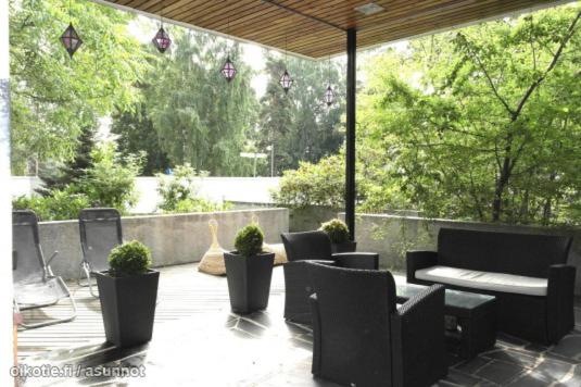 a patio with chairs and tables and potted plants at Suuri talo Kaskisaaressa lähellä Helsingin keskustaa in Helsinki