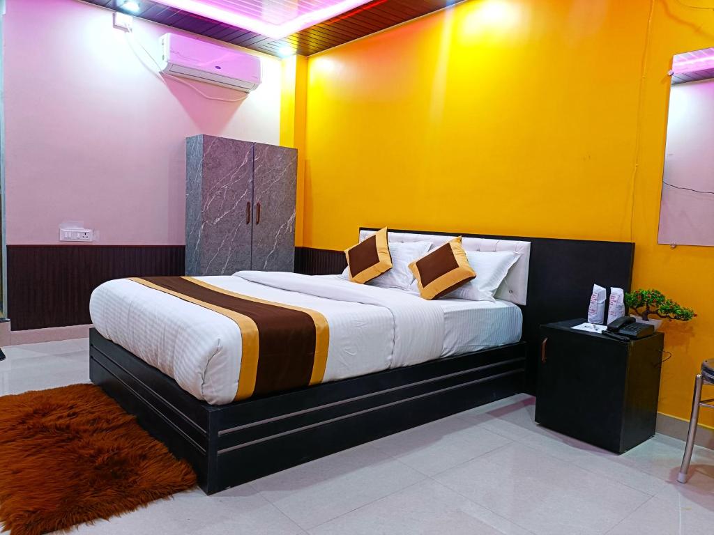 1 dormitorio con 1 cama grande y paredes amarillas en Hotel Infinity, en Rajgir