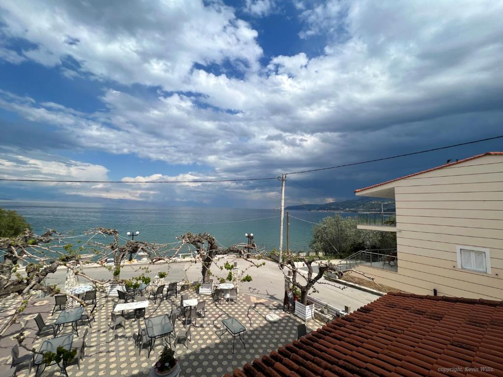 a view of the ocean from a patio with chairs at Panorama Hotel - Restaurant in Diakopto