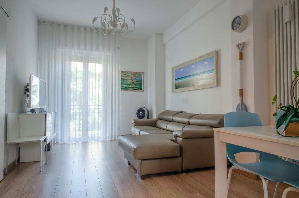 un soggiorno con un divano e un tavolo di FRONTE MARE a Pesaro