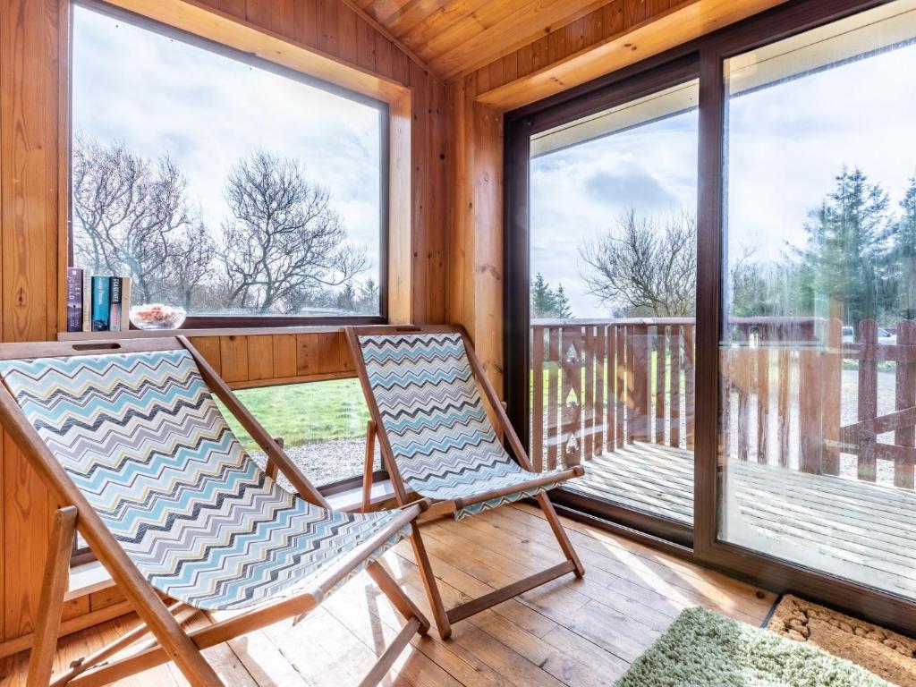 a rocking chair on a porch with large windows at 2 Bed in Clovelly 00371 in Clovelly